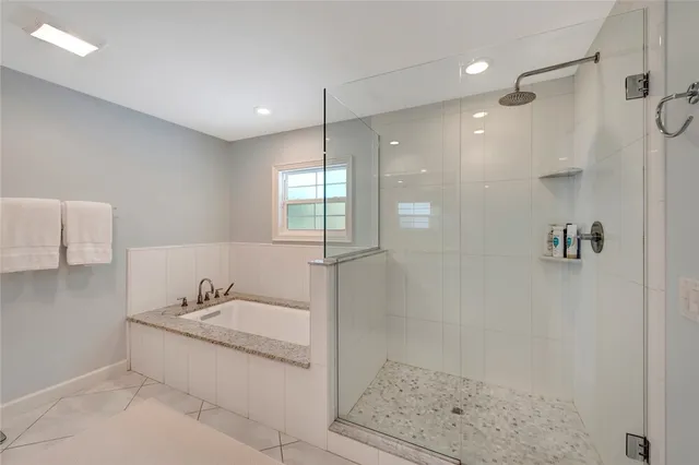 a bathroom with a granite countertop sink a mirror and shower