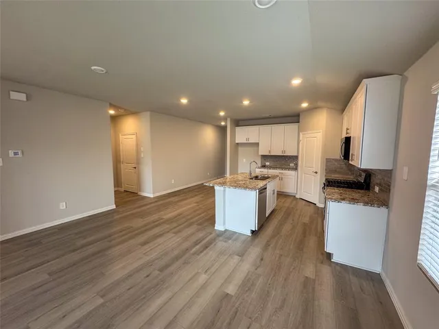 a kitchen with a refrigerator and a stove top oven