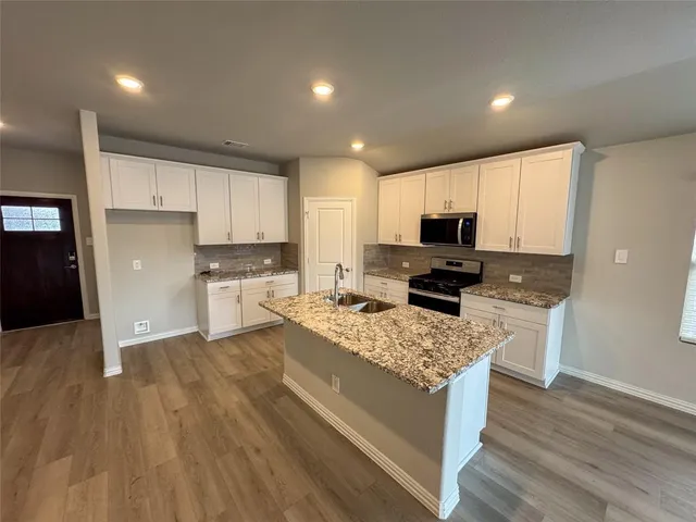 a kitchen with a refrigerator and a stove top oven
