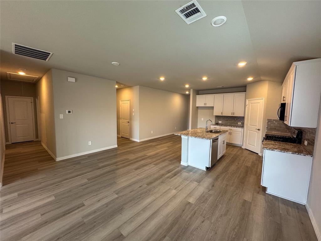 2110 Dunbar Drive Sherman, TX 75092 - Photo 8 of 22 an open kitchen with kitchen island wooden floors and stainless steel appliances