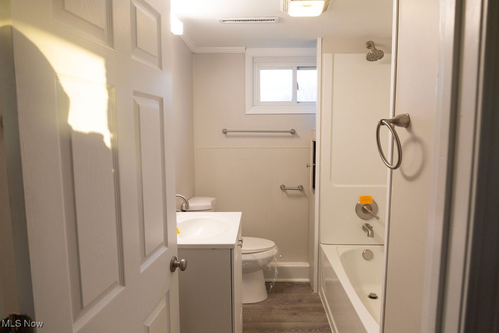 3448 Maple Road Jefferson, OH 44047 - Photo 14 of 25 Bathroom with vanity, washtub / shower combination, dark wood finished floors, and crown molding