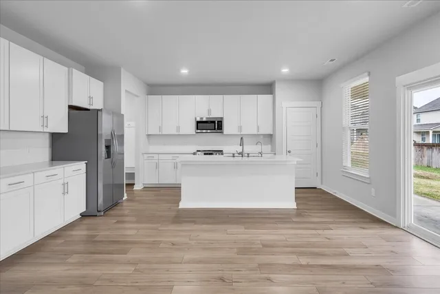 a view with kitchen stove cabinets and wooden floor