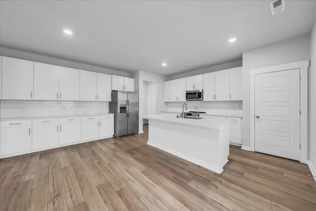 a kitchen with white cabinets and stainless steel appliances