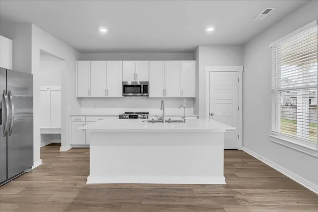 a kitchen with stainless steel appliances a sink stove and refrigerator