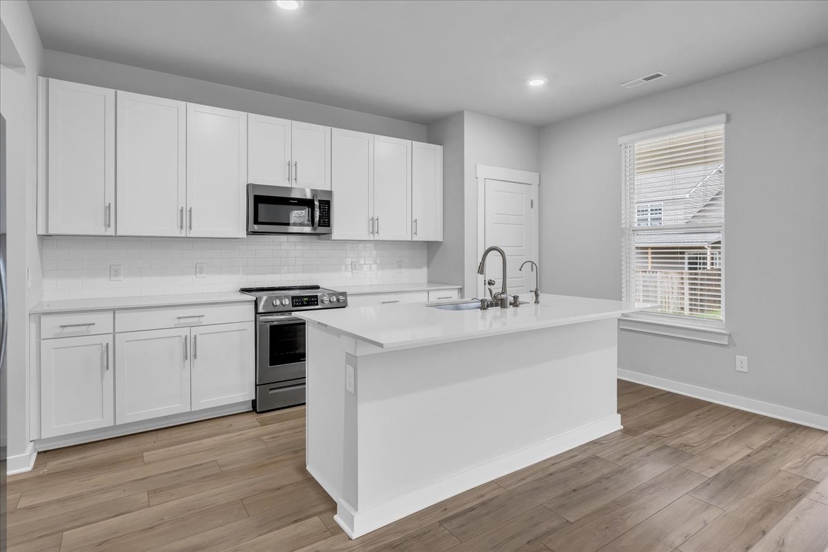 531 Mickelson Way Spring Hill, TN 37174 - Photo 21 of 57 a kitchen with stainless steel appliances granite countertop a sink a stove a microwave and cabinets