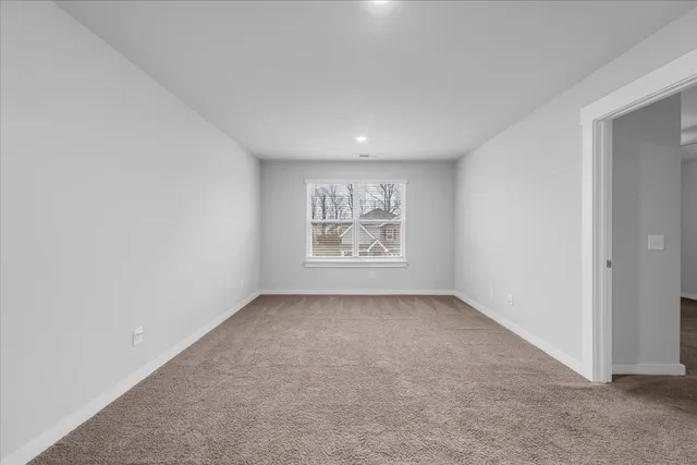 an empty room with windows and ceiling fan