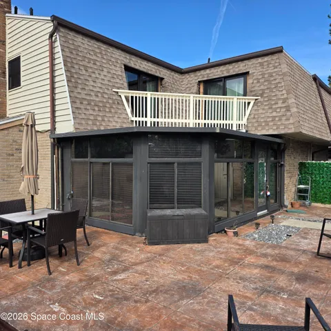 a view of a house with a patio and wooden fence