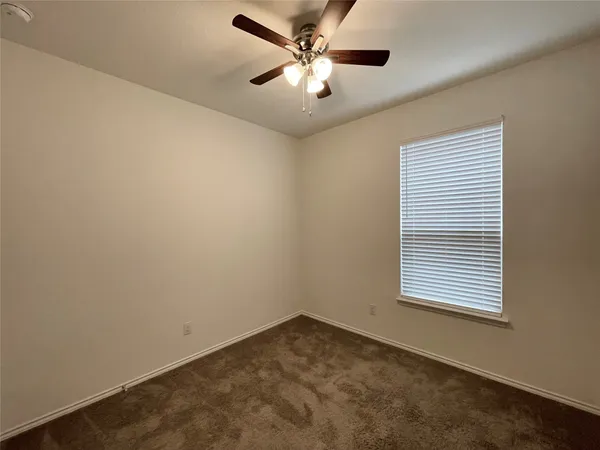 an empty room with chandelier fan