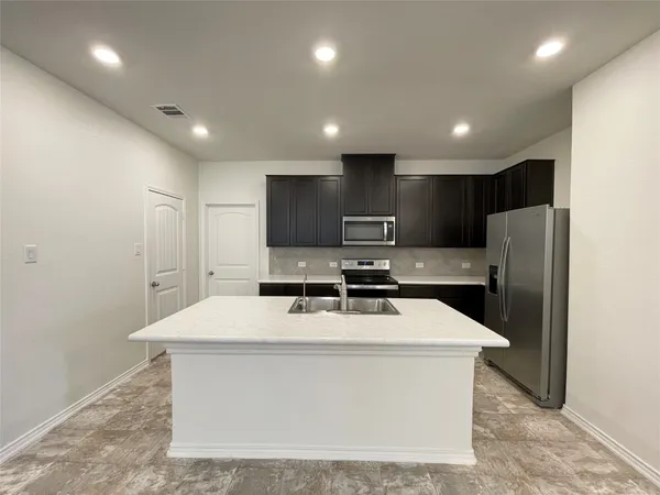 a kitchen with stainless steel appliances a refrigerator sink and microwave