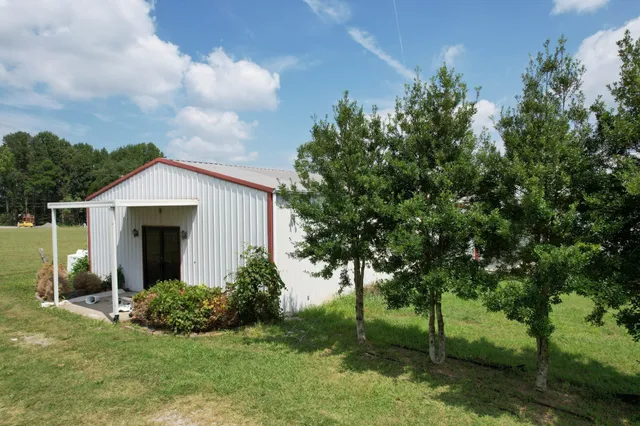 a view of a house with a yard and potted plants