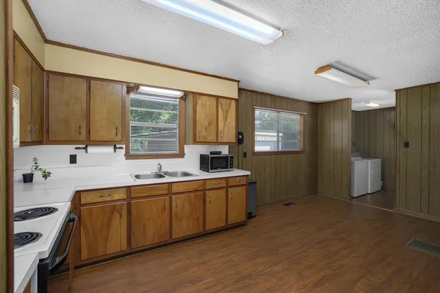 a kitchen with stainless steel appliances a sink cabinets and wooden floor