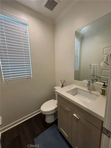 a bathroom with a granite countertop sink toilet and mirror