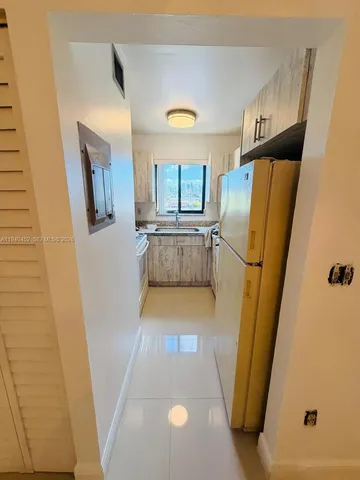 a view of a refrigerator in kitchen and a window