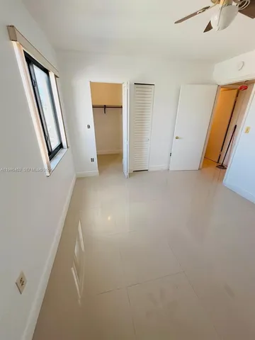 an empty room with mirror and entrance