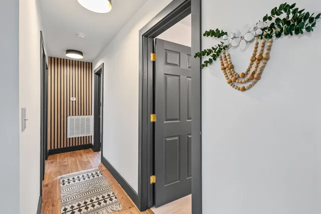 an entryway with a floor to ceiling window and a bathroom