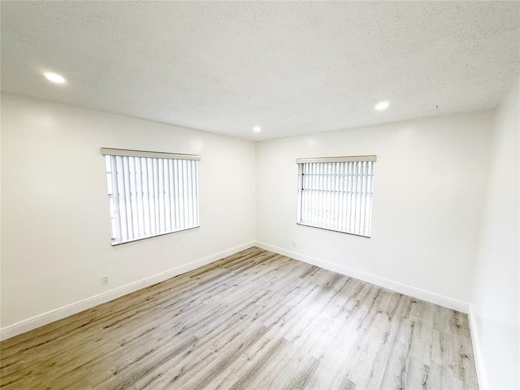 2710 Riverside Drive, Unit 201 Coral Springs, FL 33065 - Photo 14 of 37 an empty room with wooden floor and windows