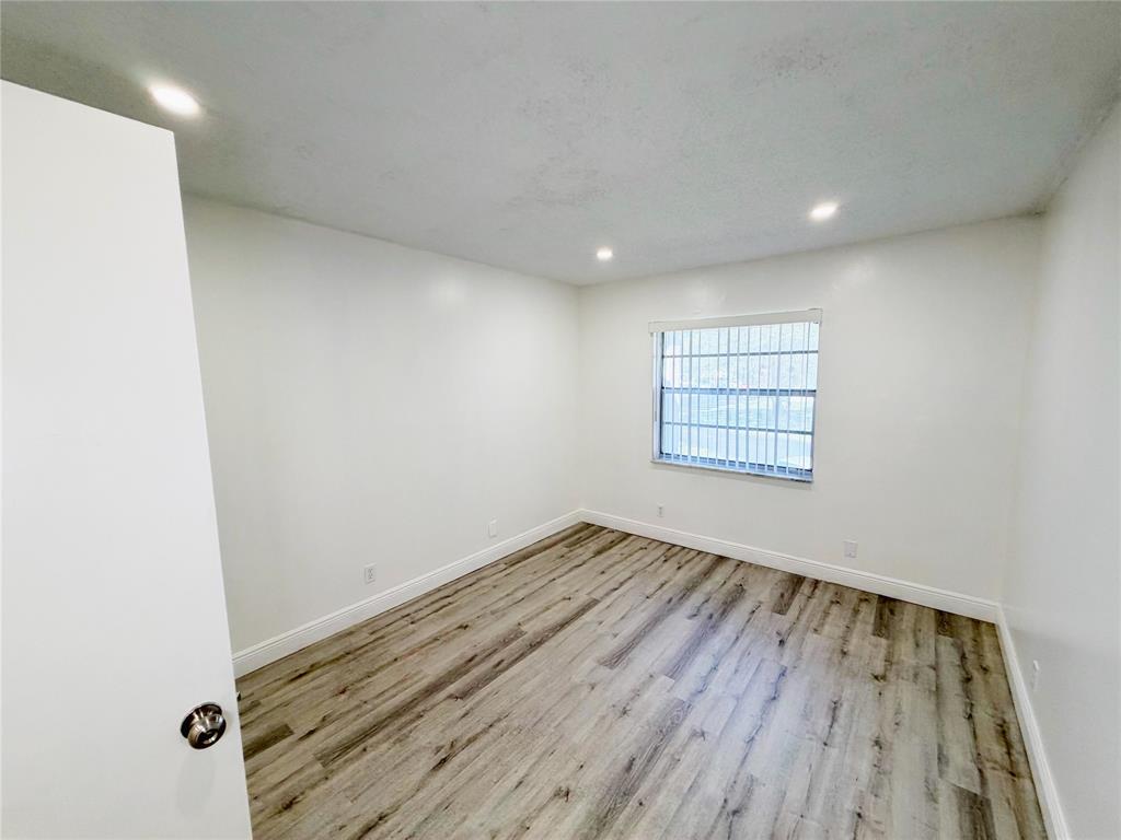 2710 Riverside Drive, Unit 201 Coral Springs, FL 33065 - Photo 26 of 37 an empty room with wooden floor and windows