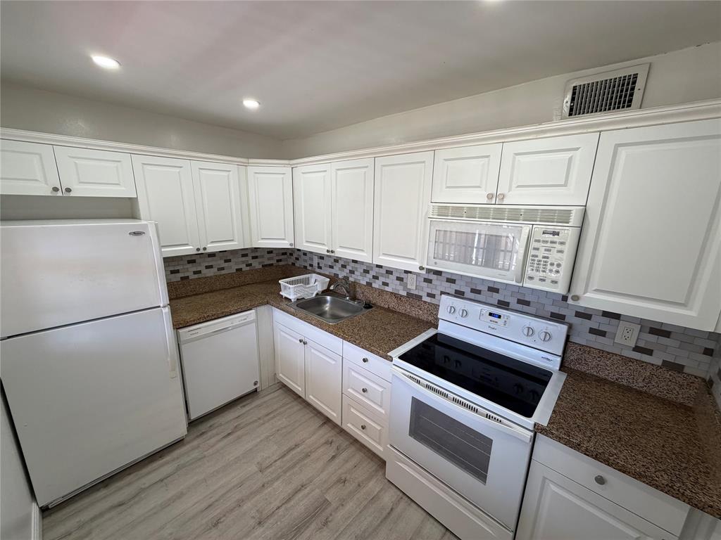 2710 Riverside Drive, Unit 201 Coral Springs, FL 33065 - Photo 5 of 37 a kitchen with granite countertop white cabinets and white appliances