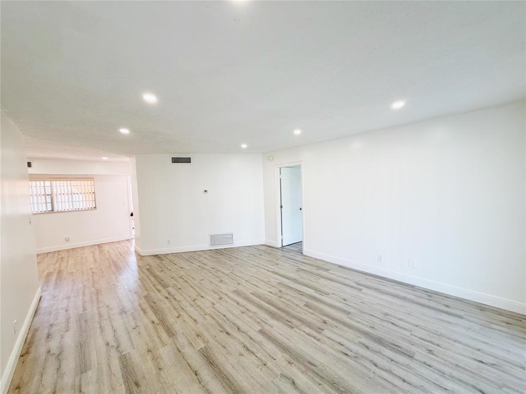 2710 Riverside Drive, Unit 201 Coral Springs, FL 33065 - Photo 10 of 37 a view of an empty room with wooden floor