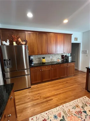 a kitchen with granite countertop a refrigerator and a sink