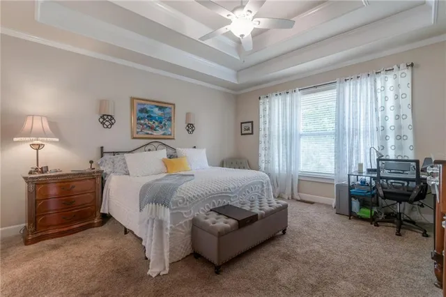 a spacious bedroom with a bed a couch and a chandelier