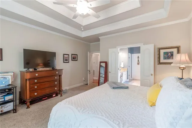 a bedroom with a bed and a flat tv screen on dresser