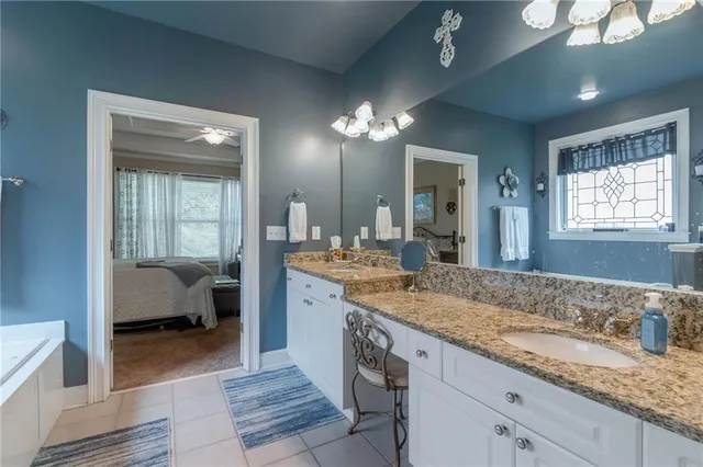 a en suite bathroom with a granite countertop sink and a mirror