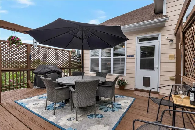 a view of a roof deck with table and chairs under an umbrella with wooden floor