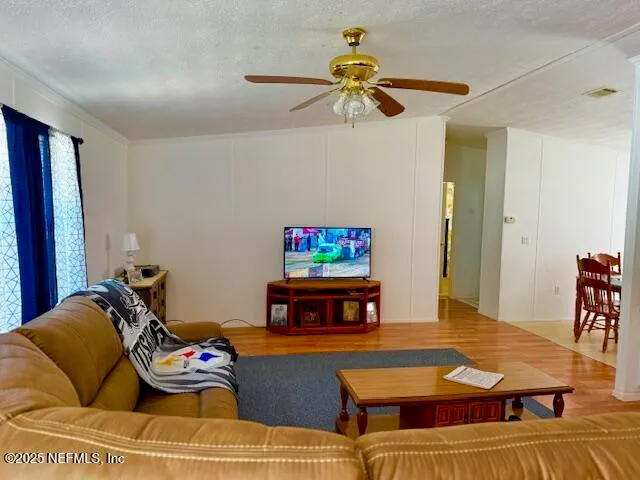 a living room with furniture and a flat screen tv with wooden floor