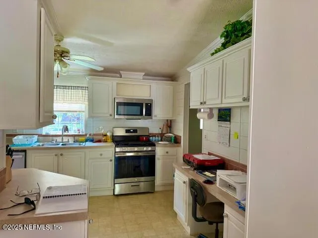 a kitchen with stainless steel appliances a stove a sink refrigerator and a microwave