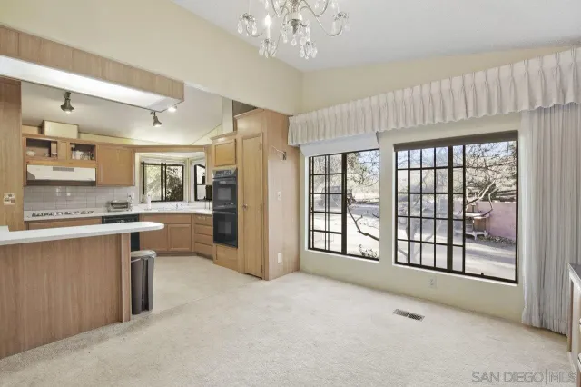 a large kitchen with granite countertop a large window and a sink