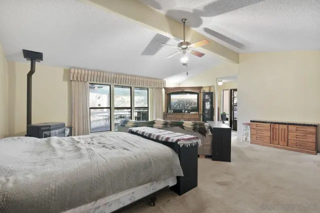 a bedroom with a large bed a flat screen tv and a large window