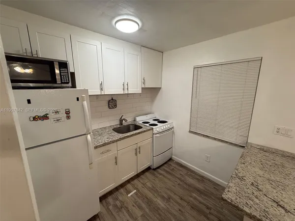 a kitchen with stainless steel appliances a sink a stove a microwave and cabinetry