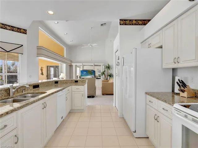 a kitchen with white cabinets and appliances