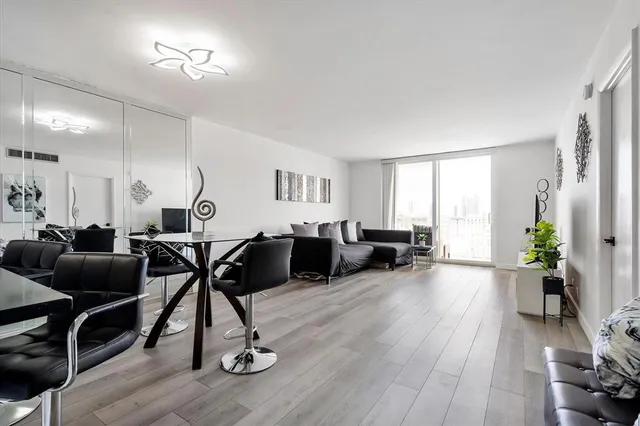 a living room with furniture gym equipment and a wooden floor