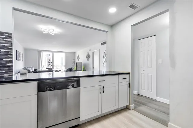 a kitchen with granite countertop white cabinets and sink