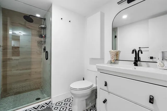 a bathroom with a sink a toilet and shower