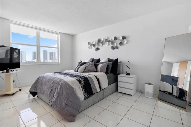 a spacious bedroom with a bed and a television