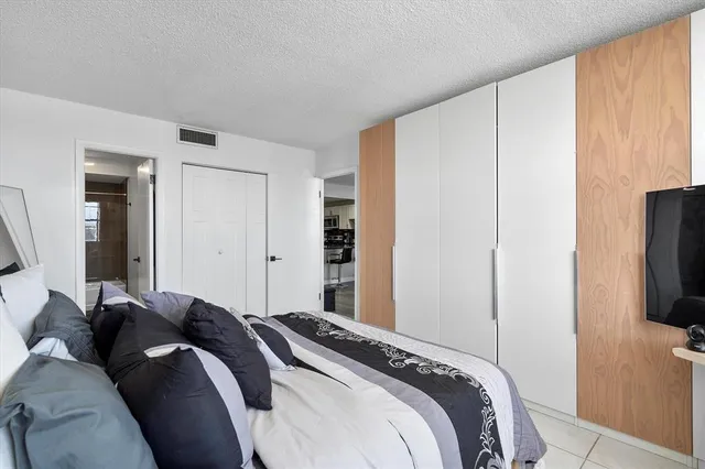 a bed room with a bed a television and a window