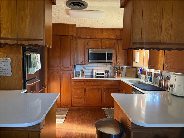 a kitchen with stainless steel appliances granite countertop a sink a stove and a refrigerator