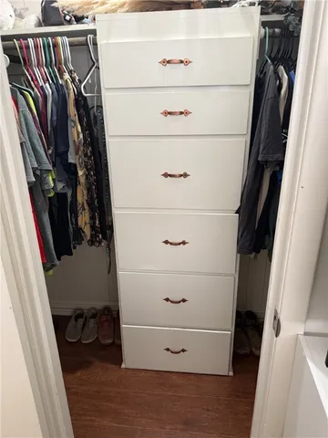 a view of walk in closet with clothes and shoes