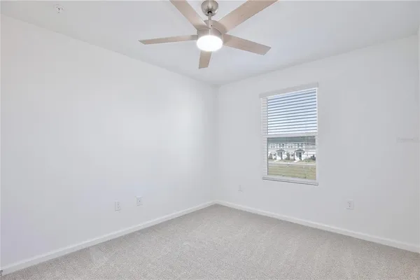 an empty room with a window and a fan