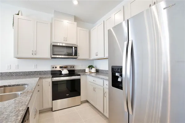 a kitchen with stainless steel appliances granite countertop a refrigerator sink and stove