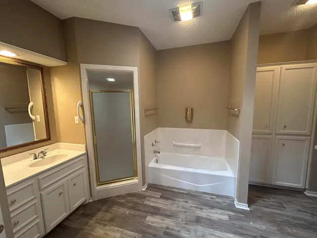 a spacious bathroom with a tub sink and mirror