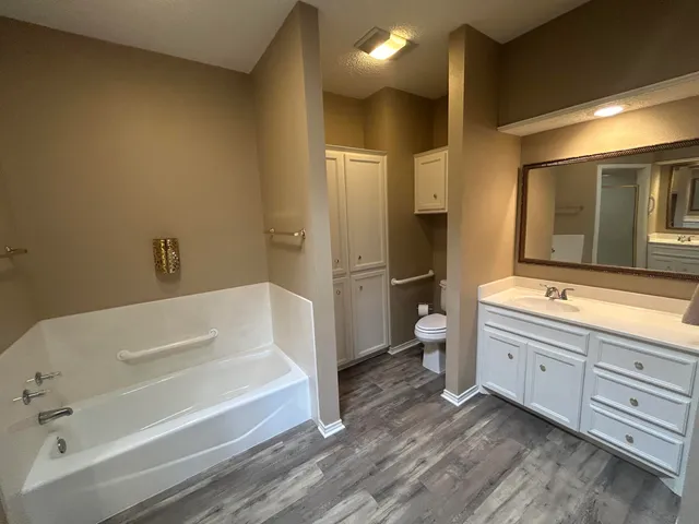 a bathroom with a tub sink toilet and mirror