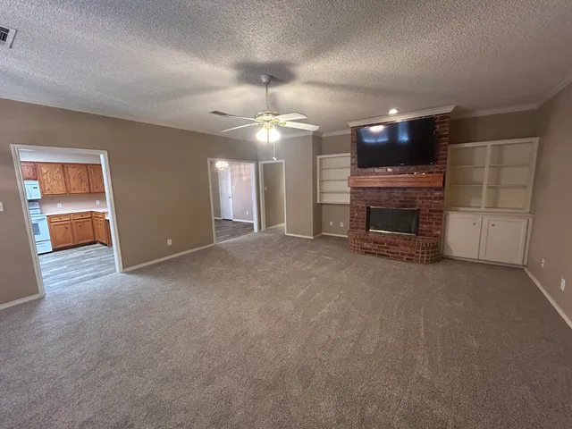 a view of an empty room with a fireplace and a window