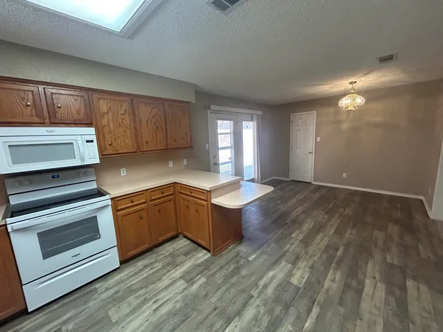a kitchen with wooden floors and appliances
