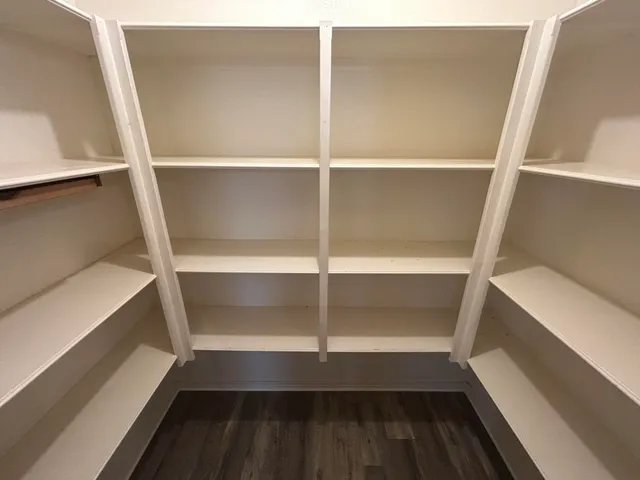a view of walk in closet with empty racks