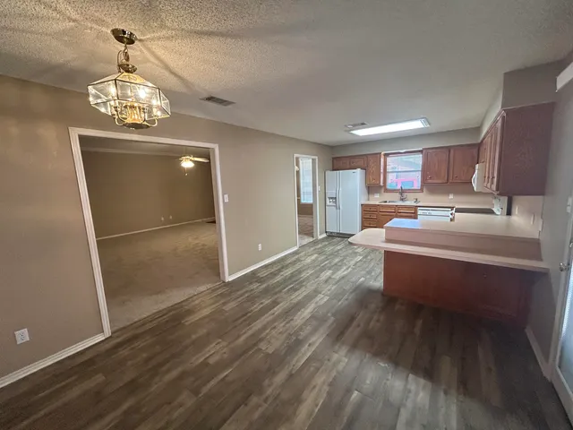 a room with wooden floor table and chairs