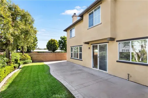 a view of an house with backyard and a tree
